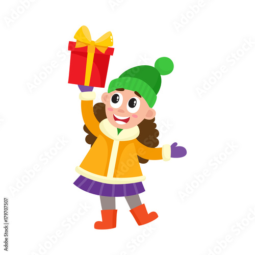 vector flat kids with presents. Young girl in outdoor winter clothing and green hat holding present box with red wrapping and yellow bow smiling. Isolated illustration on a white background.