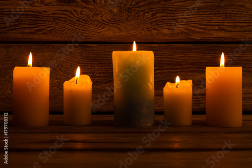 Lighted candles on wooden background.