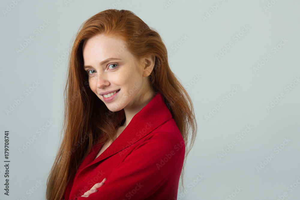 beautiful young smiling girl with red hair in a red sweater on a light background beautiful young smiling girl with red hair in a red sweater on a light background