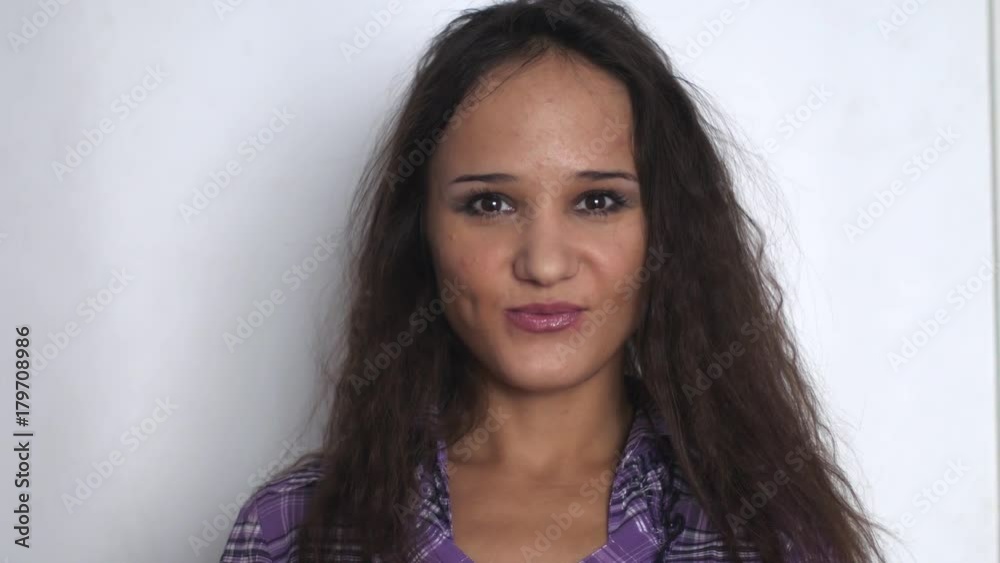 Beautiful young brunette businesswoman looking and smiling over white background. Slow motion. 3840x2160 Beautiful young brunette businesswoman looking and smiling over white background. Slow motion. 3840x2160