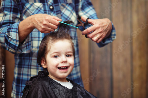 A little boy is trimmed in the hairdresser's 