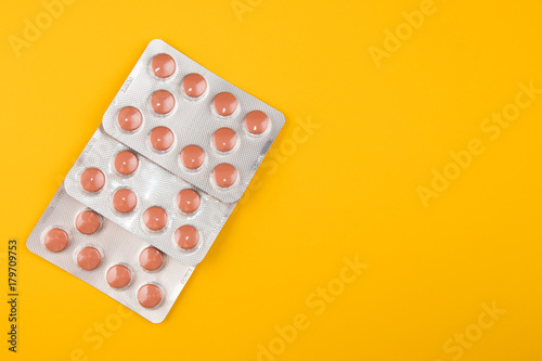 Tablets in a package on a yellow background