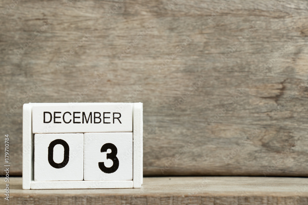 White block calendar present date 3 and month December on wood background White block calendar present date 3 and month December on wood background