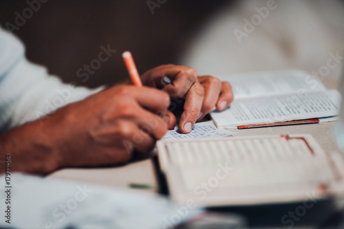 Man reading the holy Koran and making notes. Depth of field
