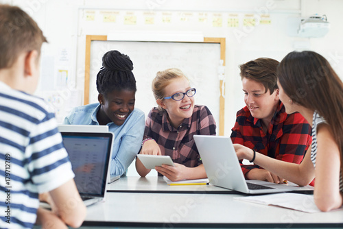 Group Of Teenage Students Collaborating On Project In IT Class