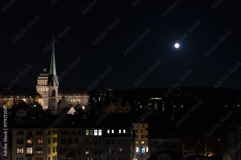 zurich city by night with full moon shinging and light on buildings
