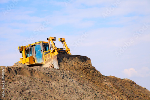 The bulldozer works on a sandy quarry.