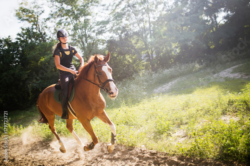 Portrait of young woman riding horse in countryside