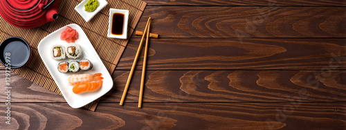 Set of sushi with red teapot and chopsticks
