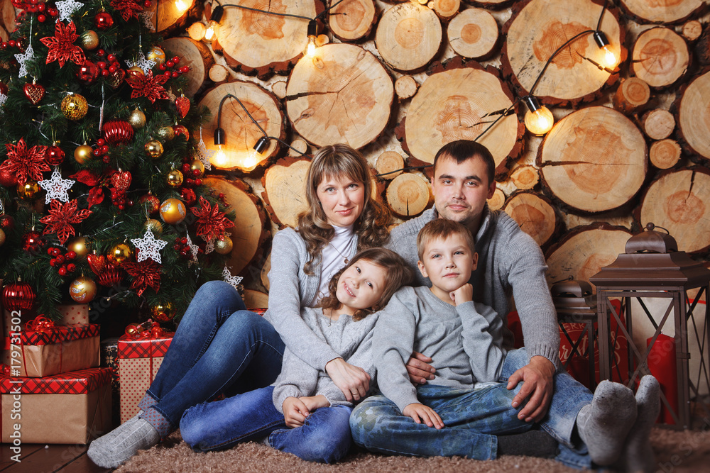Happy family celebrating Christmas and New year at the beautiful Christmas tree in your home.