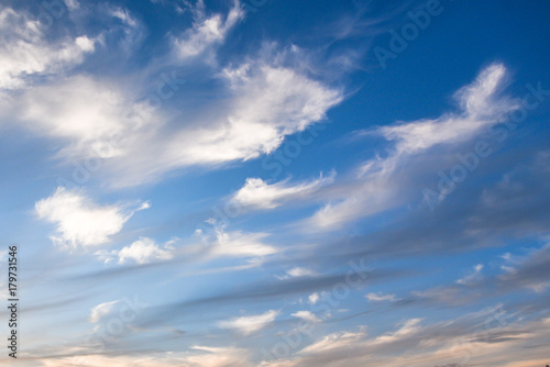 White spindrift clouds on blue sky