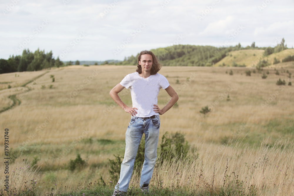 Portrait of young smiling man posing at nature