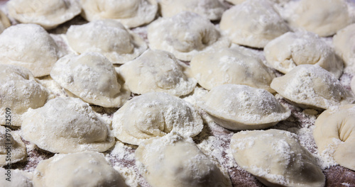 dumplings in flour on the table. Raw dumplings with handmade meat close-up.