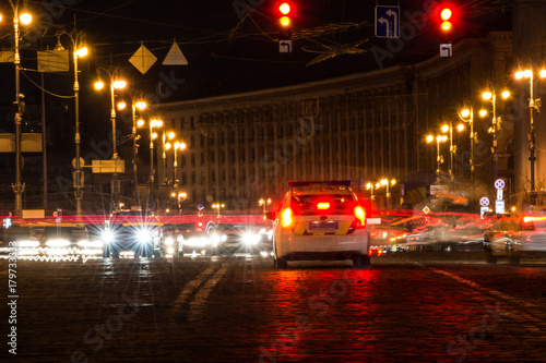 Car in the middle of a night city. Police car in the center of night Kiev. photo