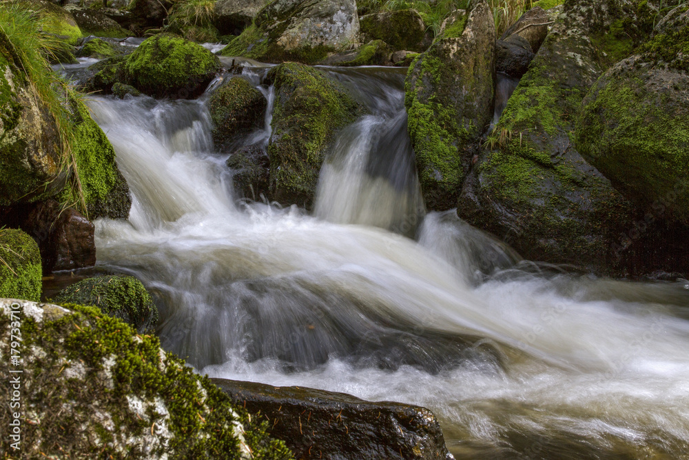 Fast-flowing water, picturesque blurred shapes of the water movement. Mossy rocks . Fast-flowing water, picturesque blurred shapes of the water movement. Mossy rocks .