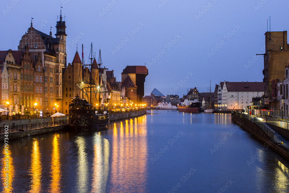 Obraz premium Views of the Old City of Gdansk, Poland, at night, with Saint Mary's gate (Brama Mariacka), the medieval crane gate (Brama Zuraw), and the Motlawa river