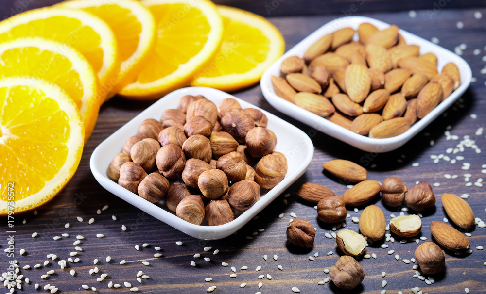 Nuts and a fresh cutting orange on wooden background Nuts and a fresh cutting orange on wooden background