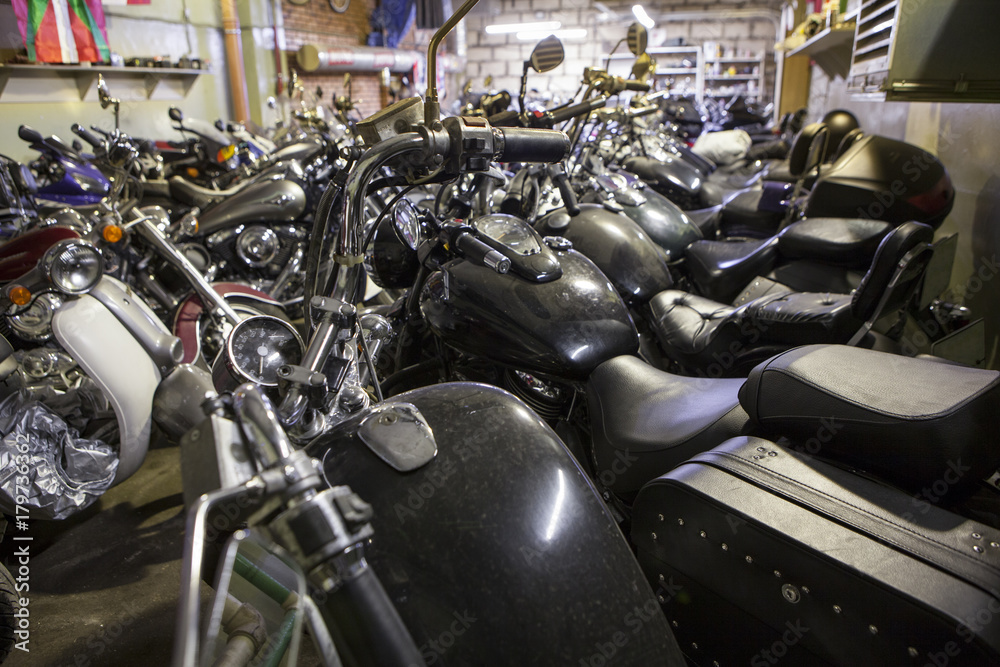 A lot of motorbikes standing in row in warm storage for overwintering in northern country