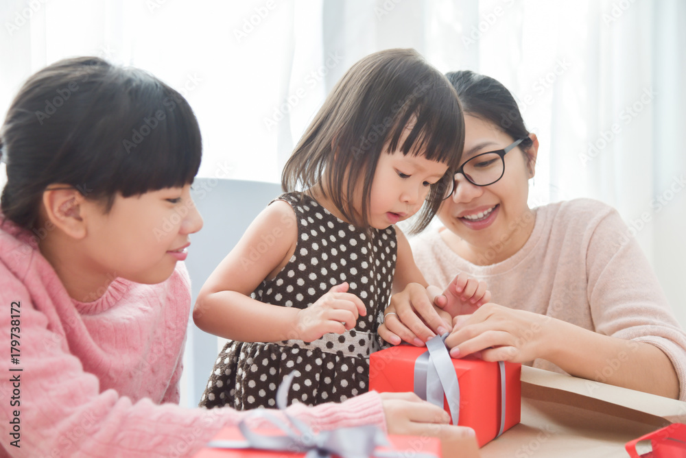 Happy Asian family wrapping a gift box. Happy Asian family wrapping a gift box.