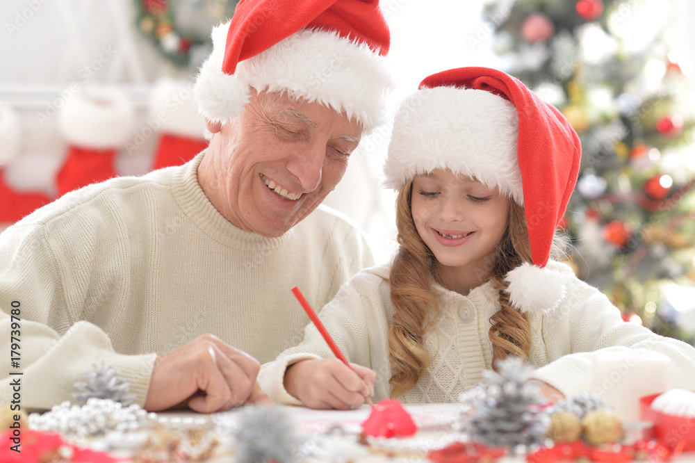 Grandfather and child in Santa hats Grandfather and child in Santa hats