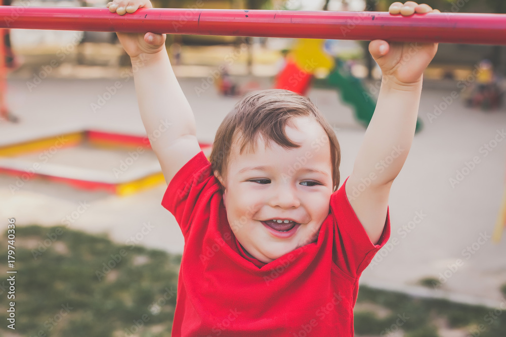 portrait of cute little boy in red t-shirt playing and smiling on playground. concept of happy healthy child portrait of cute little boy in red t-shirt playing and smiling on playground. concept of happy healthy child