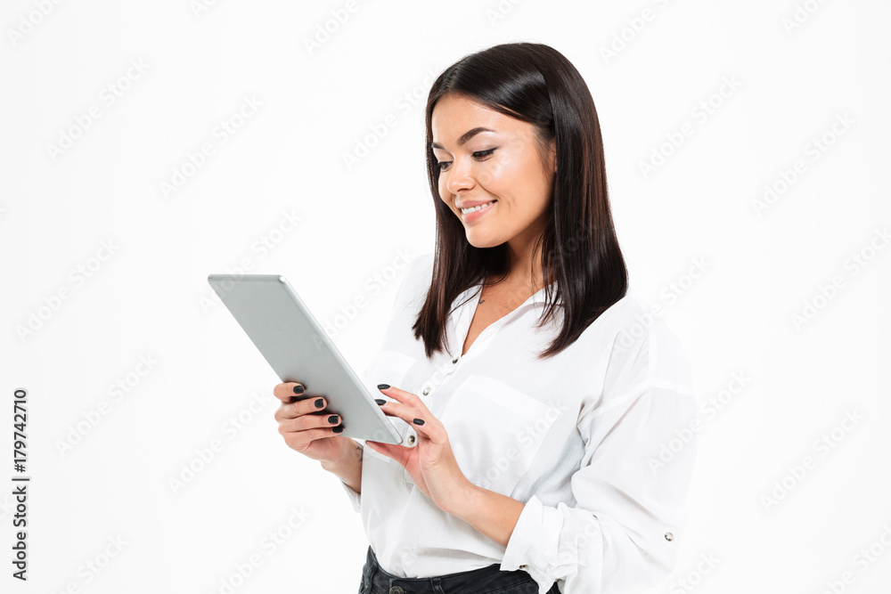 Cheerful young asian lady chatting by tablet computer Cheerful young asian lady chatting by tablet computer