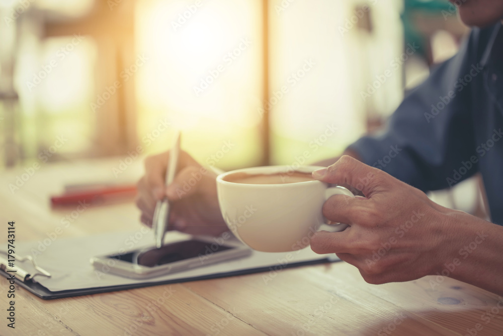 Business man writing note and drink coffee at home office. Business man writing note and drink coffee at home office.