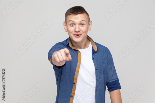 Boy pointing finger at camera and have a surprised look.