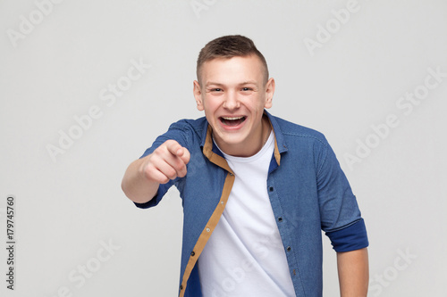 Happiness young boy pointing finger at camera and toothy smile.