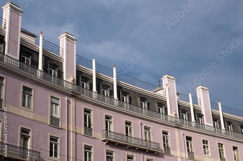 Classic European apartment building facade against cloudy sky background