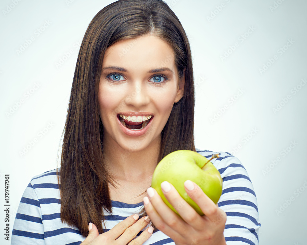 Girl smile with teeth and toothy braces holding green apple Girl smile with teeth and toothy braces holding green apple