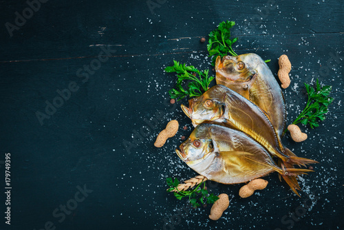 Smoked fish  Vomer. Seafood. On a wooden background. Top view. Free space for your text.