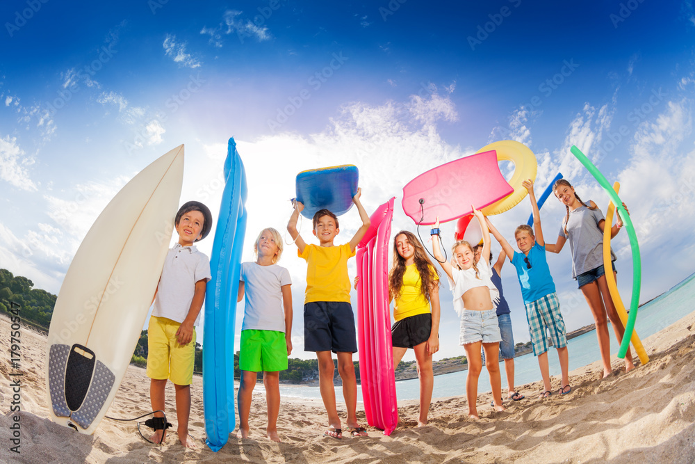 Fototapeta premium Many kids with mattresses surf boards on the beach