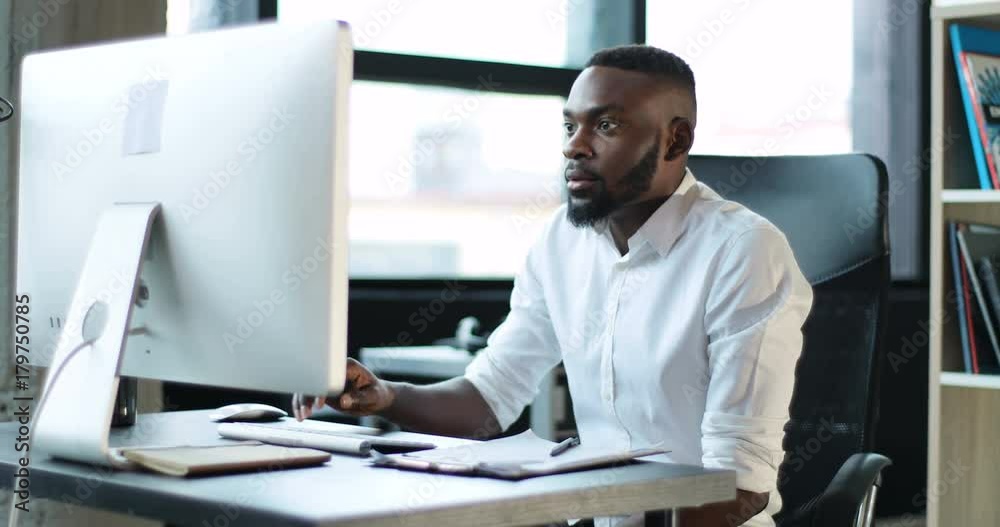 Happy young black man working use computer in office smile technology feeling pleasure african american businessman casual communication entrepreneur male successful person portrait smart business