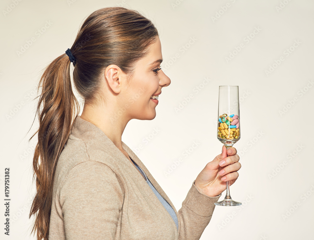 Smiling young woman holding vitamin cocktail in glass. Smiling young woman holding vitamin cocktail in glass.