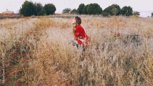 Mujer joven con un vestido rojo en el campo 