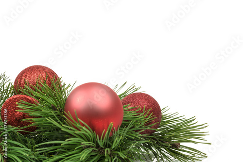 Minimalistic Christmas decoration - shiny red baubles and beads on pine twigs isolated on white background with copy space place