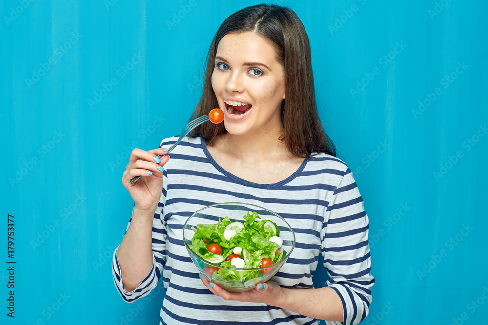 Smiling young woman eating diet food green salad. Smiling young woman eating diet food green salad.
