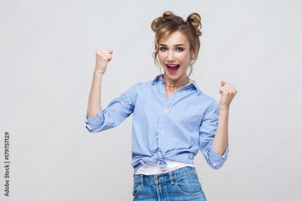 Yes! Isolated studio shot on gray background of happy successful young woman winner, feeling lucky, looking at camera, excitement and joy, smiling cheerfully. Yes! Isolated studio shot on gray background of happy successful young woman winner, feeling lucky, looking at camera, excitement and joy, smiling cheerfully.