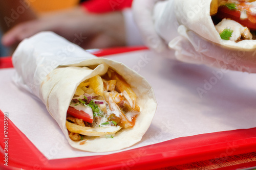 Shawarma meat chicken roll in a pita with fresh vegetables. photo