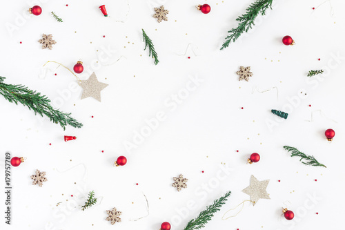 Christmas composition. Frame made of christmas tree branches  golden decorations and red berries on white background. Flat lay  top view  copy space