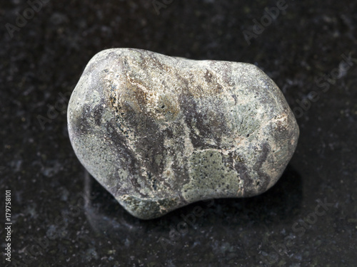 tumbled Suevite stone on dark background photo