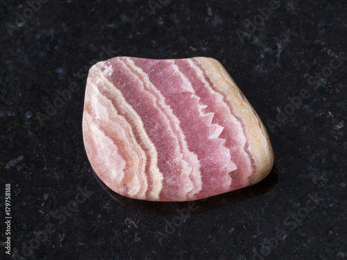 polished rhodochrosite gem stone on dark