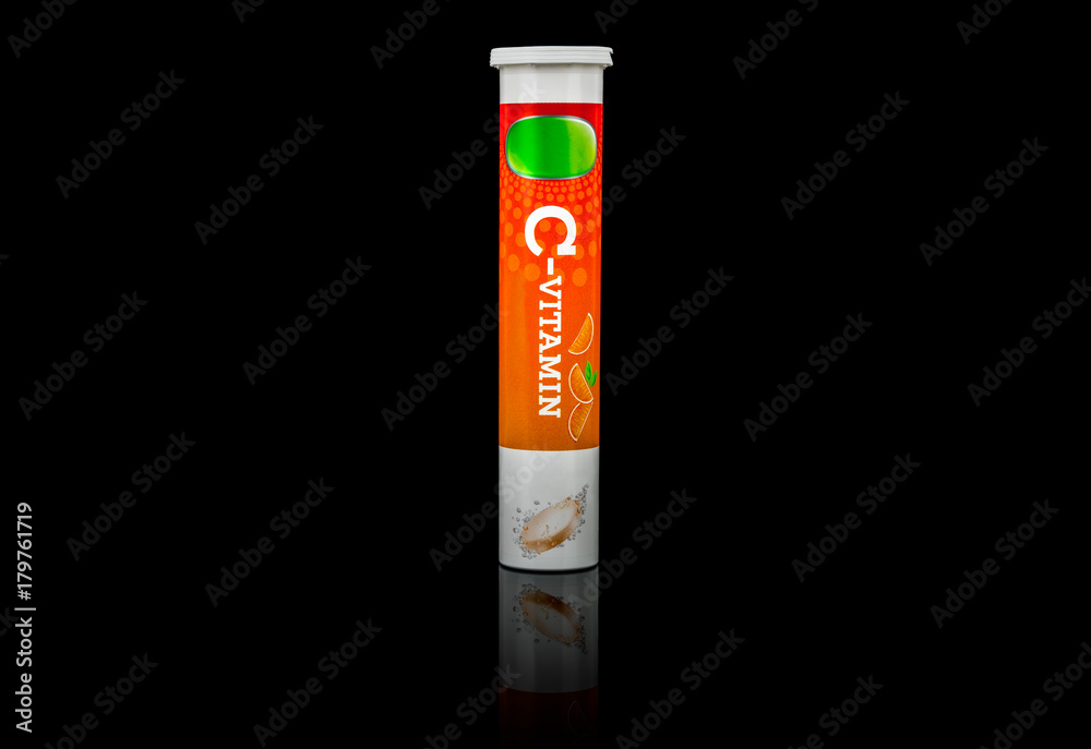 Nutritional supplement. A tube package of vitamin C effervescent tablets isolated on black background.