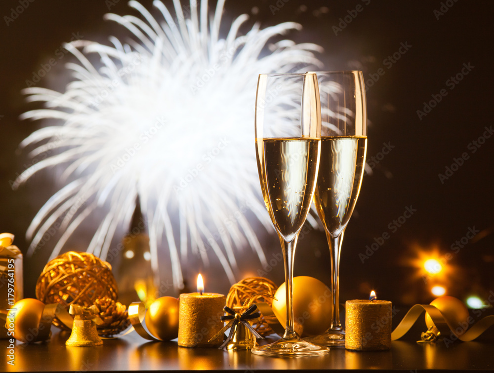 two champagne glasses against holiday lights and fireworks - new year celebration