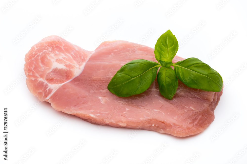 Fresh pork fillet with basil on a white background.