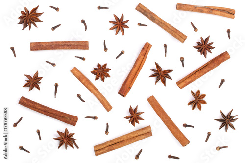 Composition of star anise, cinnamon sticks and clove isolated on white. Abstract pattern flat lay, top view photo