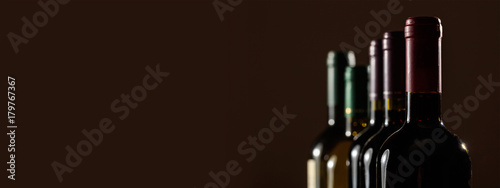 Slika na platnu Wine bottles on black background, copy space