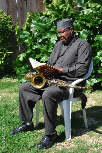 Photography Muslim jazz musician reading his book outdoors.