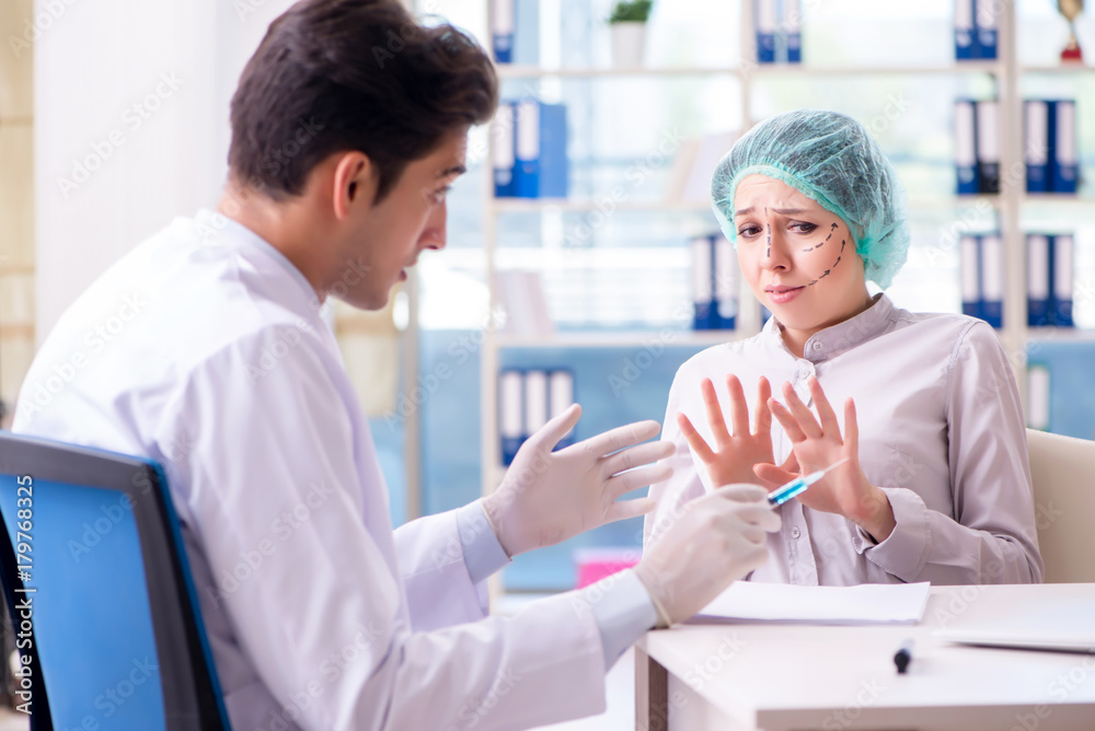 Plastic surgeon preparing for operation on woman face